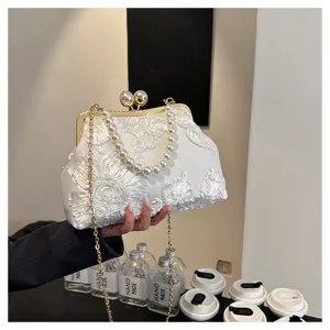 Elegant white evening clutch bag with pearl handle and detailed floral embroidery