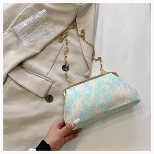 Detailansicht einer mintgrünen Muschel-Rahmentasche mit eleganter Blumenbestickung