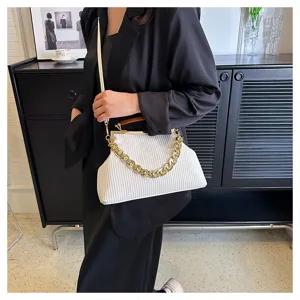Elegant white ribbed seashell handbag with chunky gold chain and amber acrylic handle detail