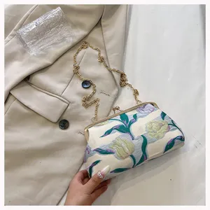 Exquisite Detailaufnahme einer floral bestickten Muscheltasche mit goldener Kette
