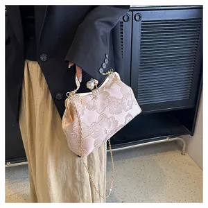 Detalle del bolso de fiesta bordado de flores rosas con cierre perla y cadena oro