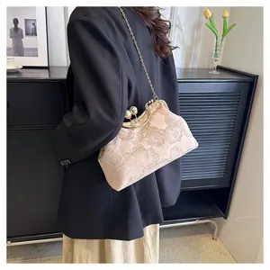 Elegant floral embroidered shell clutch with pearl clasp and gold chain strap on model