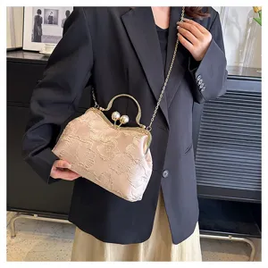 Elegante bolso bordado de flores beige con cierre de perla y detalle de cadena.