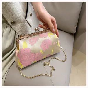 Detailansicht der eleganten, floral bestickten Clutch mit antikem Goldkettenriemen