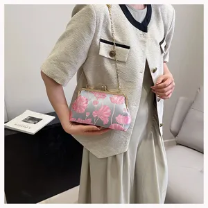 Detailansicht der modischen bestickten Muschel-Tasche mit goldenem Metall-Clip und Kette