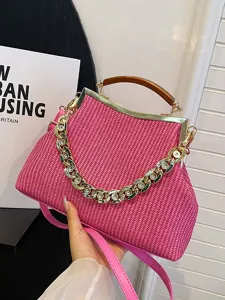 Chic pink woven handbag featuring acrylic handle and chunky gold rhinestone chain