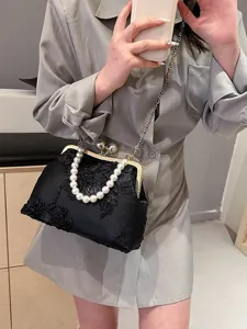 Elegant black mesh floral shell bag featuring a pearl handle and gold chain strap.