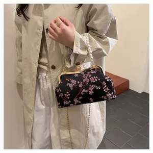 Detailansicht der bestickten floralen Abendtasche mit Perlengriff und eleganter Kette
