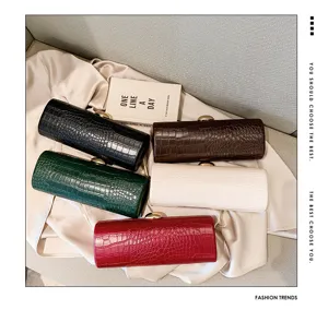 Professional top view showcasing five colorful crocodile embossed baguette clutch bags on satin