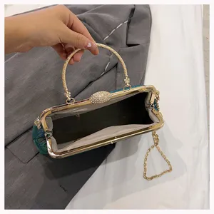 Detailansicht des Innenlebens und der goldenen Kette dieser grün bestickten Abendclutch