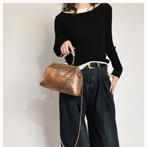 Elegantes Modell mit einer Vintage-bestickten Muscheltasche und goldener Kette