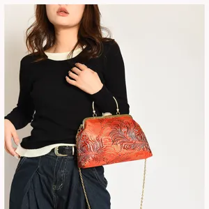 Model trägt eine Vintage-Clutch mit Prägemuster und goldfarbenem Kettenriemen.
