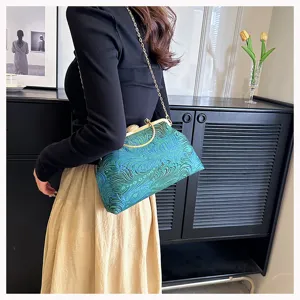 Seitenansicht der eleganten blau bestickten Abendtasche mit stilvollem goldenen Kettenriemen