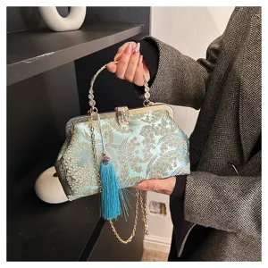 Dettaglio ravvicinato della pochette vintage ricamata a fiori con nappa di seta azzurra