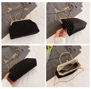 Detailansichten einer schwarzen Samthandtasche mit Goldstreifen und Metallgriff