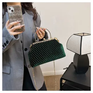 Elegante dunkelgrüne Samt-Clutch mit goldenem Vintage-Verschluss und filigranem Kettenriemen.