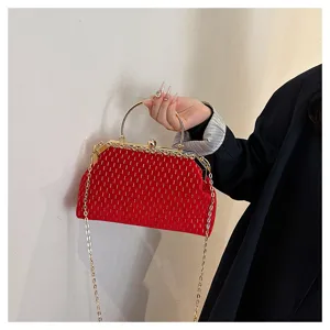 Detailansicht einer eleganten roten Samt-Clutch mit goldenen Streifen und Rundgriff