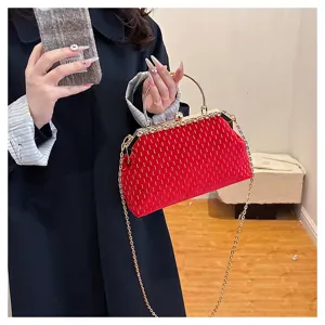Nahaufnahme einer roten Samt-Handtasche mit goldenem Griff und Strassdetails