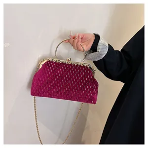 Detailansicht einer modischen fuchsiafarbenen Samt-Handtasche mit goldenen Streifen