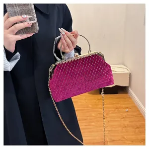 Detailansicht der magentafarbenen Samt-Clutch mit Goldgriff und Kette