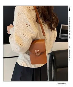 Detailed view of a brown mini crossbody phone bag with a cute cat-shaped lock