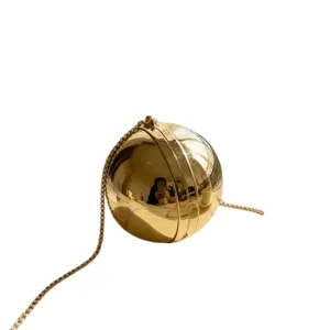 Detail view of a luxury spherical golden evening clutch bag with long metallic chain strap