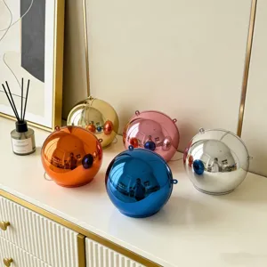 Collection of spherical acrylic evening clutch bags in multi-color metallic finishes