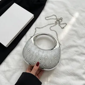 Primer plano de un bolso de fiesta plateado brillante con diamantes d'imitación.