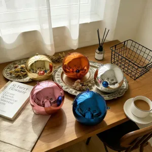 Macro shot of multiple colorful metallic spherical evening clutches on a wooden table.
