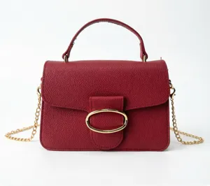 Elegant wine red pebbled leather handbag with gold oval buckle and chain strap detail.