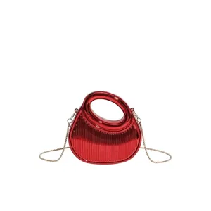 Metallic red acrylic crescent evening bag with ribbed texture and gold chain strap
