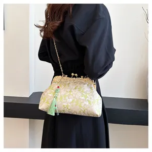 Close-up of vintage floral embroidered handbag with green tassel and gold chain strap