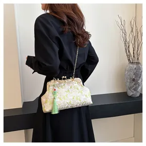 Elegant beige embroidered handbag with green floral patterns and a silk tassel charm.