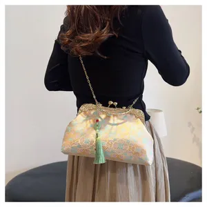 Elegant vintage embroidered crossbody bag featuring a green tassel and gold chain strap