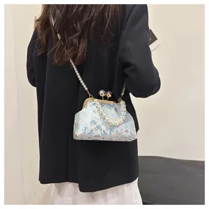 Vista posteriore di una modella con borsa a conchiglia ricamata con manico e tracolla di perle