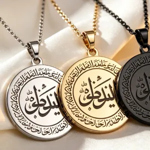 Close-up of stainless steel round pendant necklaces with Arabic calligraphy engraving details.