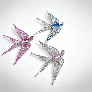 Detailed view of three elegant swallow brooches with sparkling rhinestones in three colors