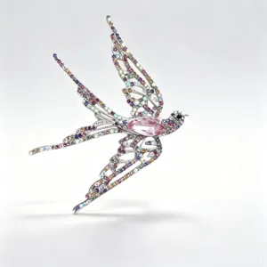 Detailed macro view of the sparkling crystal swallow brooch with a pink center stone.