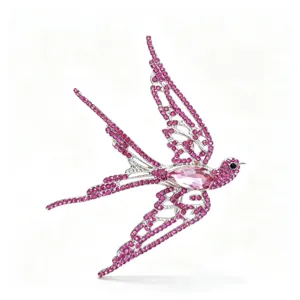 Detailed view of pink rhinestone-encrusted swallow brooch with pear-shaped center crystal