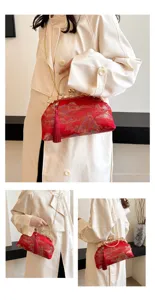 Detailansicht einer roten bestickten Abendtasche mit Seidentextur und goldener Quaste