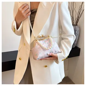 Dettaglio della borsa da sera rosa ricamata con tracolla di perle e chiusura a scatto.