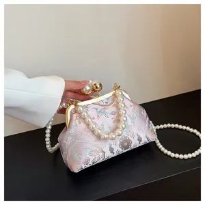 Vista dettagliata della borsa a conchiglia ricamata rosa con manici in perle e chiusura