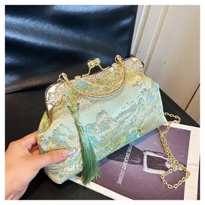 Detailansicht einer bestickten Abendtasche mit grüner Quaste und goldener Kettenschulter