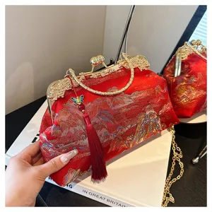 Rote bestickte Abendtasche mit Quaste und goldener Kette in Nahaufnahme