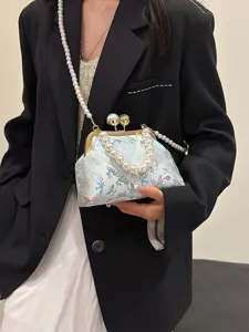Elegante borsa a mano ricamata a conchiglia con tracolla di perle mostrata su modella.