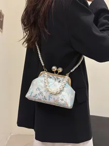 Elegante borsa a conchiglia ricamata con manico di perle e chiusura.