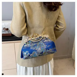 Elegante blau bestickte Abendtasche mit Quaste und Kettenriemen am Modell getragen