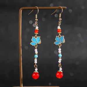 Vue détaillée de boucles d'oreilles vintage chinoises, papillons bleus et perles rouges.
