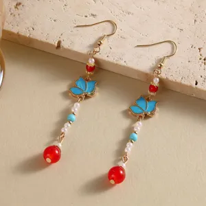 Vue détaillée de boucles d'oreilles Hanfu traditionnelles avec papillons et perles rouges.