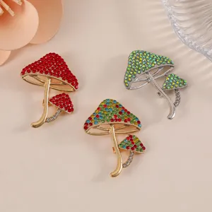 Detailed view of colorful rhinestone-encrusted mushroom brooches on beige background.